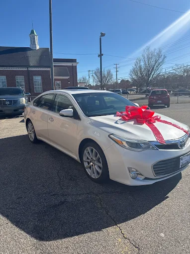 Customer Toyota Avalon with red ribbon ready for delivery at Beach Auto Sales